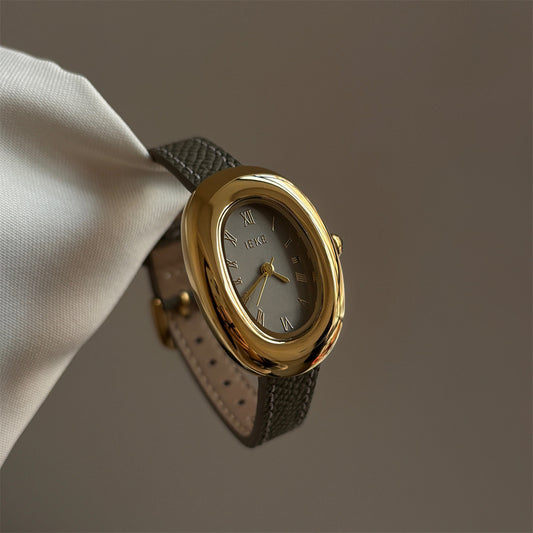 Olive-colored strap watch with a gold oval dial, featuring a niche design